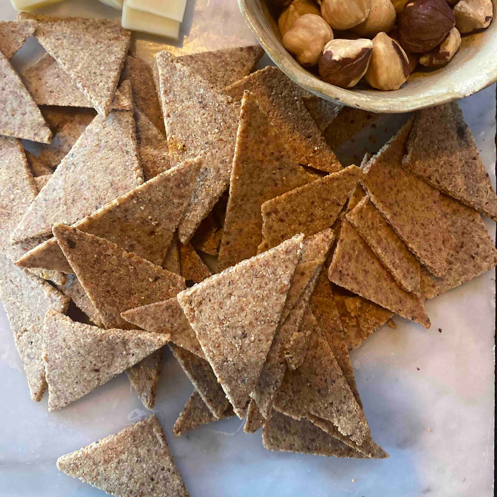 Galleta triangular de harina de almendras con suave toque de merkén, para aperitivos, colaciones, picoteo, servir con ensaladas o acompañando alguna comida.