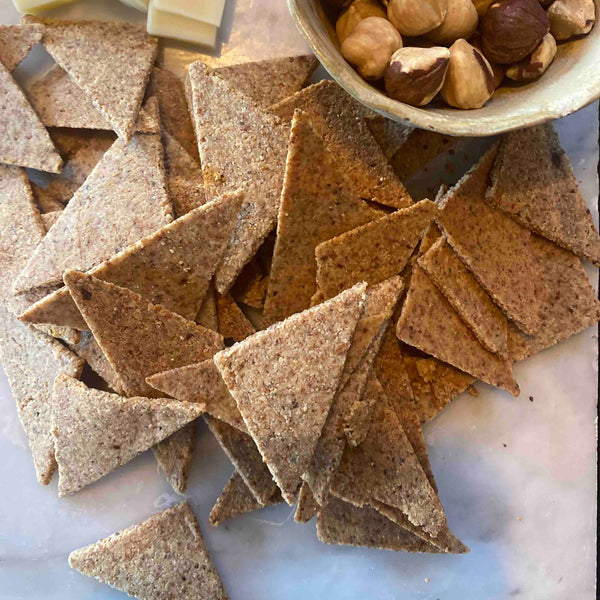 Galleta triangular de harina de almendras con suave toque de merkén, para aperitivos, colaciones, picoteo, servir con ensaladas o acompañando alguna comida.